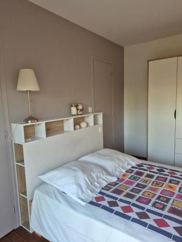 a bedroom with a bed and a lamp in it at Chambre avec salle de bain privée in Saint-Gervais