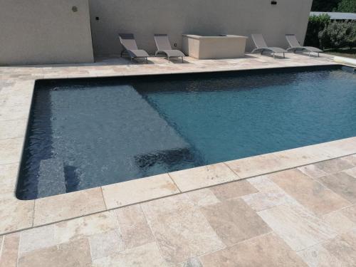 ein großer Pool mit Stühlen im Hof in der Unterkunft Maison de 80m2 avec cour fermée et sécurisée in Crozes-Hermitage