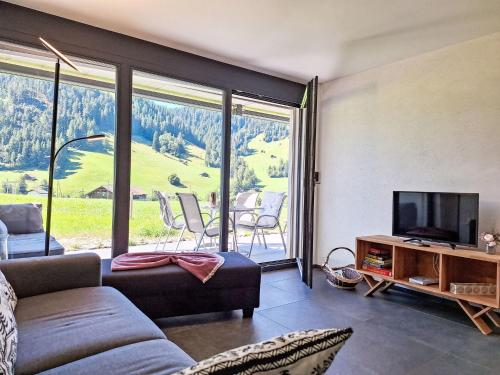 Una sala de estar con televisión y una gran ventana. en Apartment Greenview by Interhome, en Blankenburg