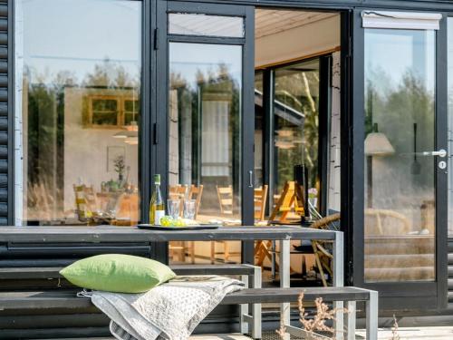 a table with a green pillow on a patio at Holiday Home Shayene - 2-5km from the sea by Interhome in Læsø