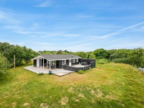 a house with a large yard with a deck at Holiday Home Bentine - 400m from the sea by Interhome in Fanø