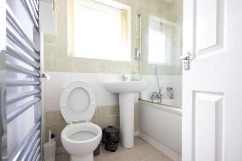 een badkamer met toilet, wastafel en raam bij Stanhope - Sizewell - Contractor Accommodation in Snape