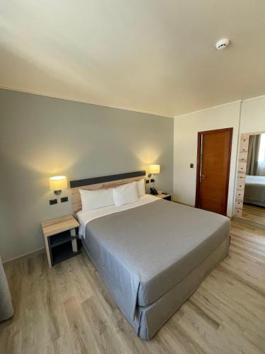 a bedroom with a large bed with two tables and two lamps at Diego de Almagro Providencia Express in Santiago