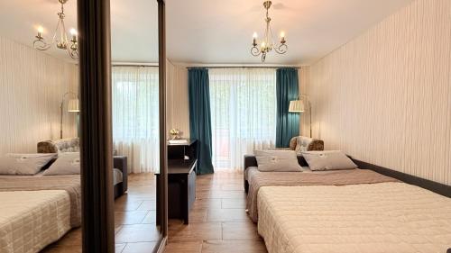 a hotel room with two beds and a mirror at Covent - Garden - Kharkiv in Kharkiv