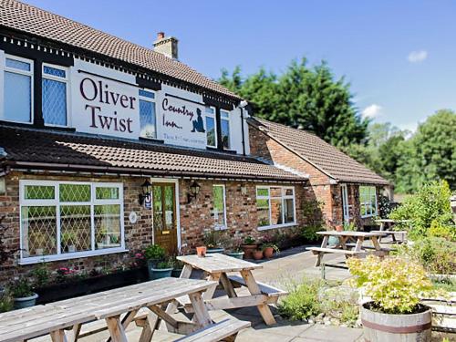 a group of picnic tables in front of a building at Oliver Twist Country Inn in Wisbech
