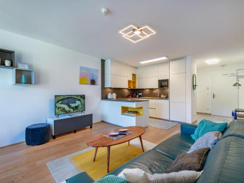 een woonkamer met een bank en een tafel bij Apartment Top 5 Alpe maritima Seeblick-Bergkulisse by Interhome in Annenheim