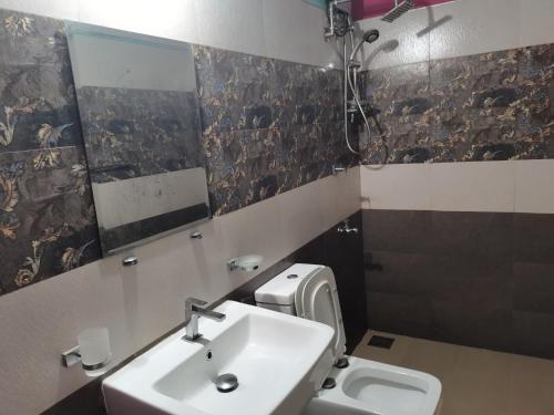a bathroom with a sink and a toilet at Ceylon Traveller Homestay in Panadura
