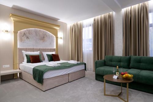 a hotel room with a bed and a couch at Ивелия Хотел и Спа - Ivelia Hotel & SPA in Dŭbnitsa