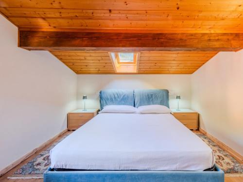 a bedroom with a large bed with wooden ceilings at Apartment Mansarda in Legno San Rocco by Interhome in Carisolo