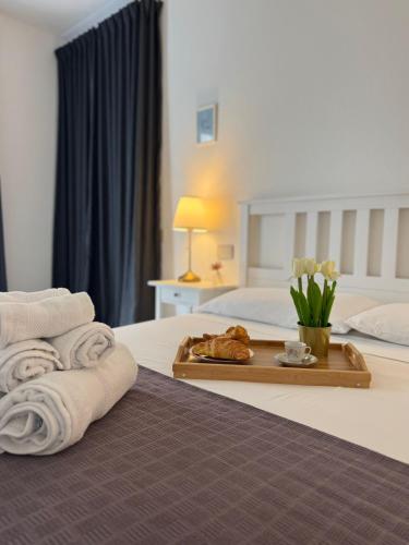 a hotel room with a bed and a tray of towels at L'obiettivo in Assemini