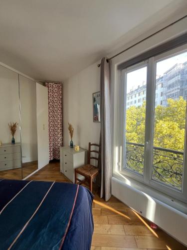 a bedroom with a bed and a large window at Charming 2 room appartement in Paris