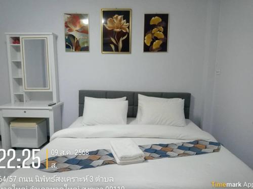 a bedroom with a bed with two pillows and a mirror at Jaydahouse hatyai in Sathani Hat Yai
