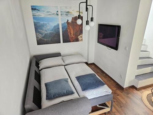 Habitación con 1 cama con 2 almohadas y TV. en Lendhäuschen, en Klagenfurt