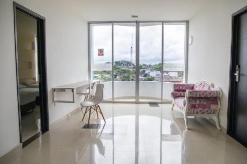 ein Wohnzimmer mit Tisch und Stühlen und einem Fenster in der Unterkunft Hotel Confort Ariari in Granada