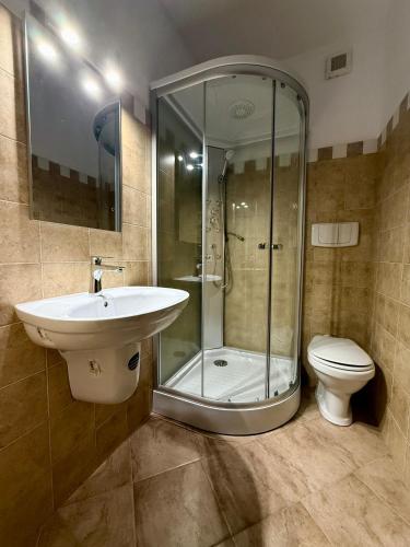 a bathroom with a shower and a sink and a toilet at Imperial in Moisei