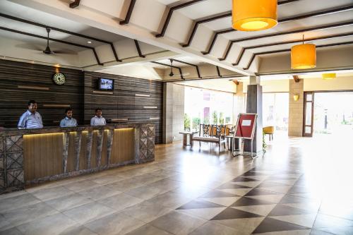three men standing at a bar in a restaurant at Nanu Beach Resort & Spa in Betalbatim