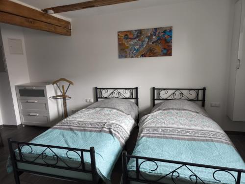 two beds sitting next to each other in a bedroom at Ferienwohnung zwischen Steigerwald und Frankenhöhe für 2-3 Personen, barrierefrei in Gallmersgarten