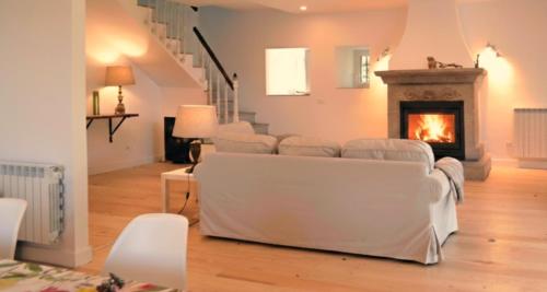 a living room with white furniture and a fireplace at Casa Sayanes in Vigo
