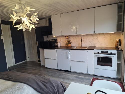 a kitchen with white cabinets and a chandelier at Tofta in Växjö