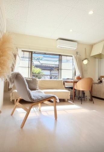 a living room with a couch and a chair at 伊勢神宮内宮前-民泊宿i s e s h i m a -205 in Ise