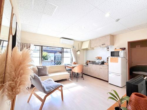 een woonkamer met een bank en een keuken bij 伊勢神宮内宮前-民泊宿i s e s h i m a -205 in Ise