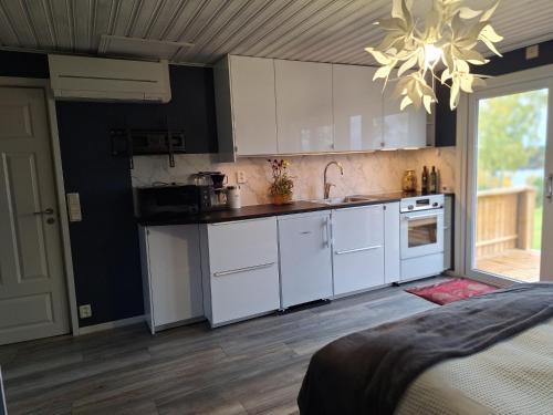 a kitchen with white cabinets and a chandelier at Tofta in Växjö