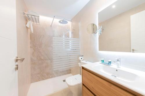 オビエドにあるSilken Apartamentos Goyaの洗面台、トイレ、鏡のあるバスルーム