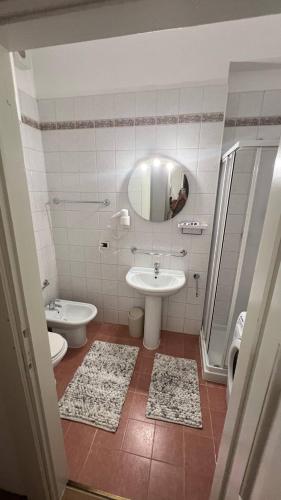 a bathroom with a sink and a toilet and a mirror at Appartament Tribulaun in Colle Isarco
