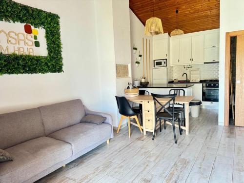 a living room and kitchen with a couch and a table at Casa da Capela - Casa BemHaja in São Miguel de Acha