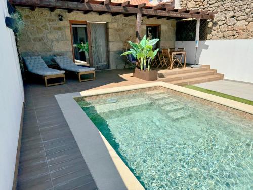 a swimming pool in front of a house at Casa da Capela - Casa BemHaja in São Miguel de Acha