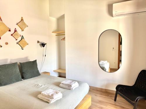 a bedroom with a bed with a mirror on the wall at Casa da Capela - CASAS BEMHAJA in São Miguel de Acha