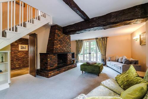 un salon avec une cheminée en briques et un canapé dans l'établissement Apple House by Staycay, à Nether Alderley