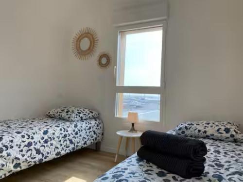 ein Schlafzimmer mit zwei Betten und einem Fenster in der Unterkunft T3 with large roof-top terrace, harbor view in Gruissan