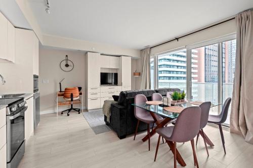 a kitchen and living room with a table and a couch at Panoramic 2 Bedroom plus Den Condo Yonge Street Downtown Toronto in Toronto