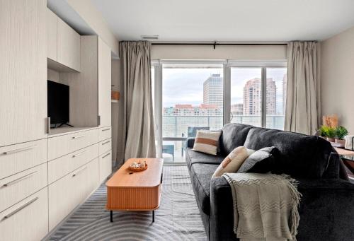 a living room with a couch and a large window at Panoramic 2 Bedroom plus Den Condo Yonge Street Downtown Toronto in Toronto