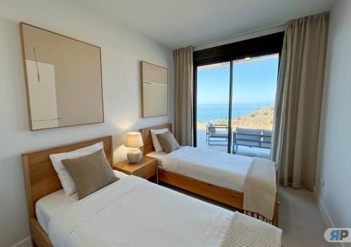 Dos camas en una habitación con vista al mar. en 013 Apartamento Sonne con terraza, en Rincón de la Victoria