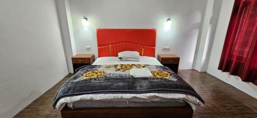 a bedroom with a large bed with a red headboard at Hotel Thangshing In in Lachung