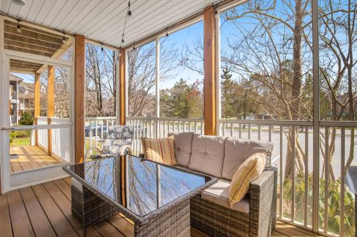 a screened in porch with a couch and a glass table at Sea Colony - 56046 Pinewood Dr in Bethany Beach