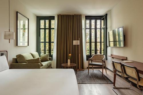毕尔巴鄂Batimont Suites & Apartments的一间带床和客厅的酒店房间
