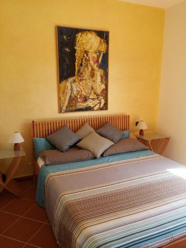 - une chambre avec un lit et un tableau au-dessus dans l'établissement Villetta Via Nenni, à Porto San Paolo