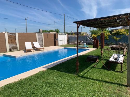 a swimming pool with two chairs and a gazebo at Don Caffe in San Pedro