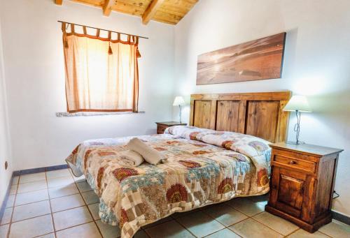 a bedroom with a bed and a table and a window at ISA - Residence with swimming pool in Badesi just 300 mt from the sea in Badesi