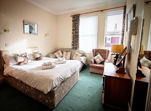 a bedroom with a large bed and a couch at Viking Guest House in Bridlington