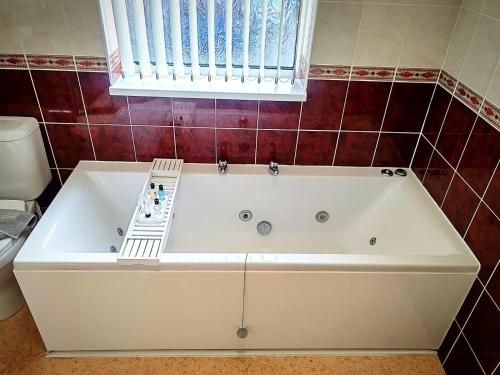 a white bath tub in a bathroom with a window at Viking Guest House in Bridlington