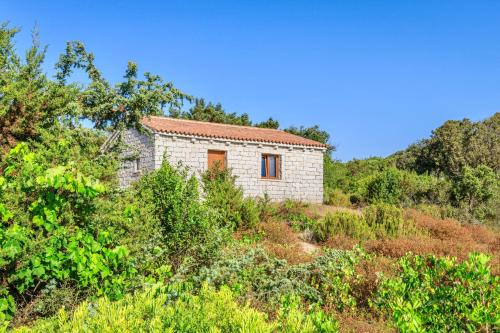 an old stone house on a hill with trees at ISA - Residence with swimming pool in Badesi just 300 mt from the sea in Badesi