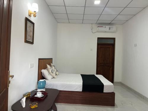 a bedroom with a bed and a table in a room at Sigiri Sihina Villa in Inamaluwa