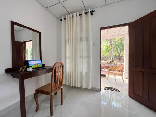 a desk with a mirror and a chair in a room at Sigiri Sihina Villa in Inamaluwa