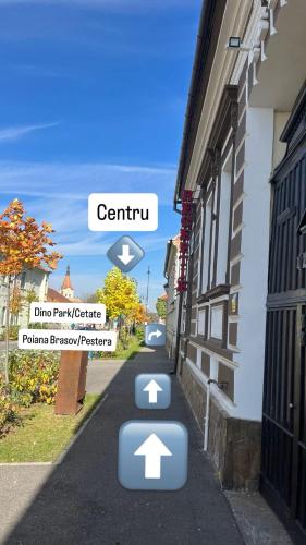 a street with arrows on the side of a building at Cetățuia - Ultra Central Râșnov Stay & Parking free in Râşnov