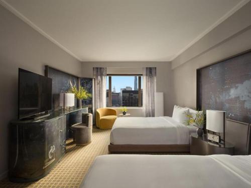 a hotel room with two beds and a flat screen tv at Hotel The Caves in New Delhi