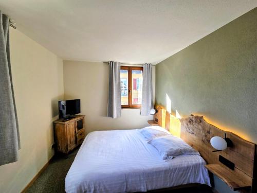 un dormitorio con una cama y una ventana en Hotel le Chasseur, en Illkirch-Graffenstaden